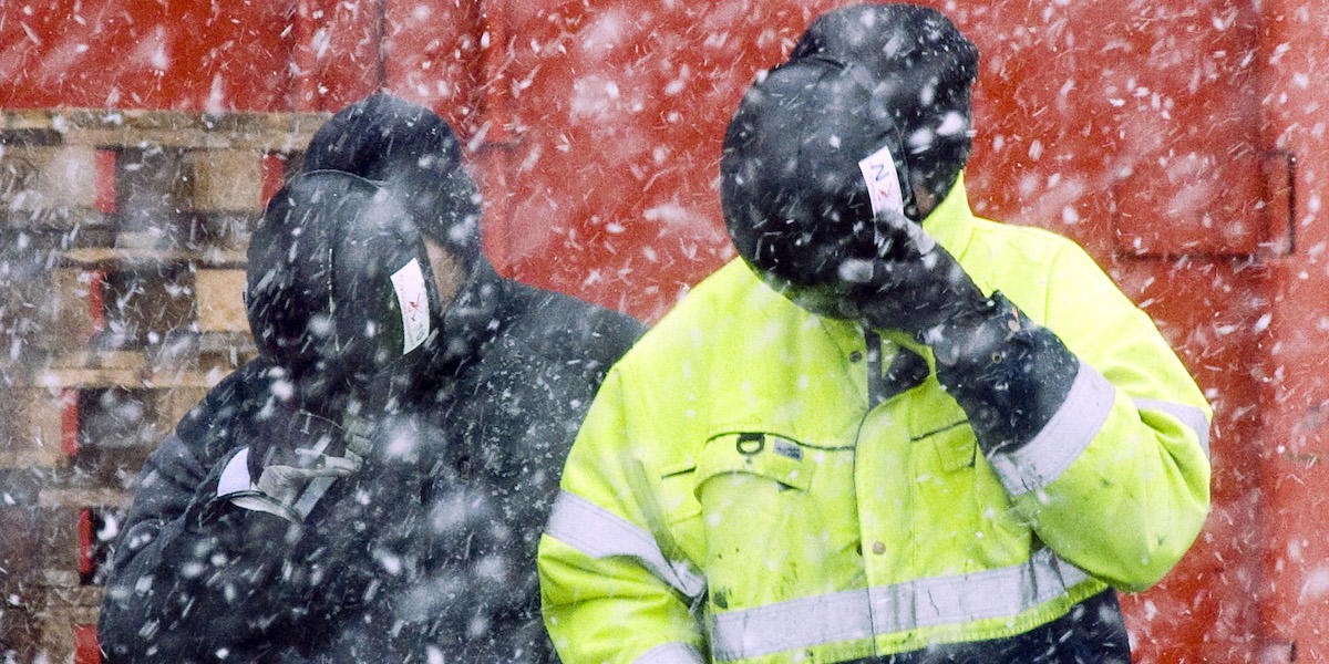 Två byggjobbare i snöoväder håller hjälmar för ansiktet som skydd. En ny svensk studie visar inom vilka yrken män har störst risk för självmord och självmordsförsök
